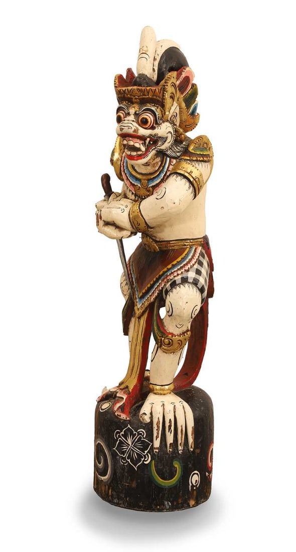 A Balinese carved wood temple guardian, 20th century or later,: A Balinese carved wood temple guardian, 20th century or later, of Hanuman, polychrome painted and carved with bulging eyes and bared teeth, holding a kris 93cm high