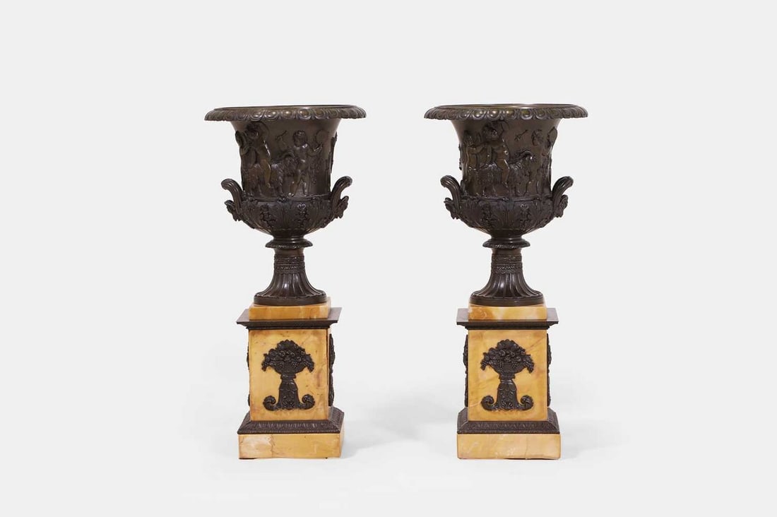 A pair of grand tour patinated bronze 'Medici' vases, circa 1825,: A pair of grand tour patinated bronze 'Medici' vases, circa 1825, each of typical form, the flared gadrooned rim above a body decorated primarily with figural cherub scenes, flanked by handles in the 