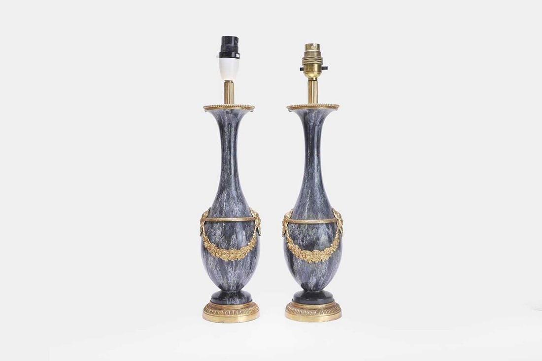 A pair of Louis XVI-style ceramic and gilt-metal-mounted table lamps, 20th century,: A pair of Louis XVI-style ceramic and gilt-metal-mounted table lamps, 20th century, each of slender baluster form with mottled glaze, mounted with gilt-metal mask and foliate swags, and raised on a ci