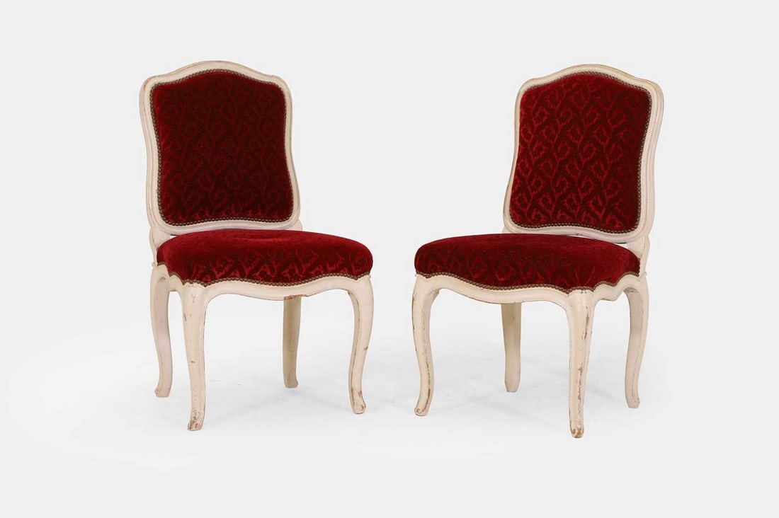 A pair of Louis XV white-painted side chairs, second quarter of the 18th century,: A pair of Louis XV white-painted side chairs, second quarter of the 18th century, each cartouche back over a shaped seat, covered in red velvet floral upholstery, raised on cabriole legs, one stamped 