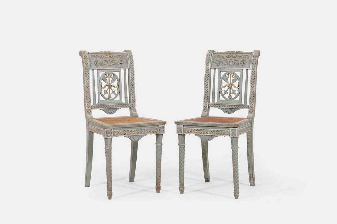 A pair of Louis XVI green-painted side chairs, late 18th century,: A pair of Louis XVI green-painted side chairs, late 18th century, each carved top rail with floral and swag decoration above a cartouche splat with arrow detail, further flanked by upright splats in t