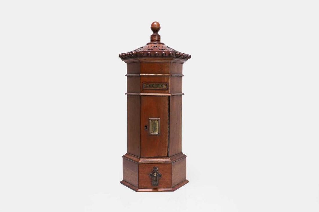 A mahogany country house postbox, late 19th/early 20th century,: A mahogany country house postbox, late 19th/early 20th century, of hexagonal outline, the carved foliate and beaded top centred by a finial, above a brass letter flap (25cm diameter, 57cm high) Condit