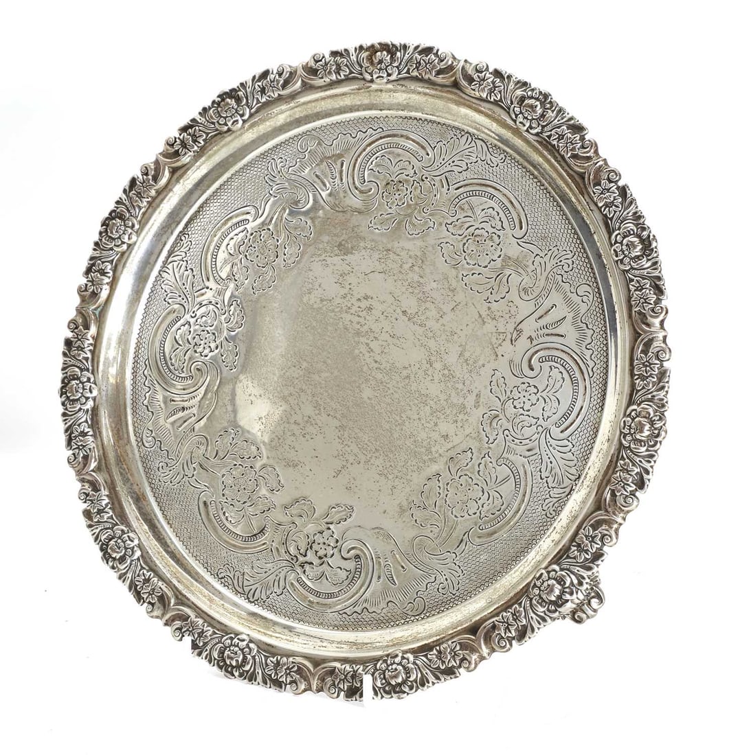 A small silver salver, S C Younge & Co, Sheffield, 1818,: A small silver salver, S C Younge & Co, Sheffield, 1818, with cast foliate frieze, and engraved decoration 25cm diameter, 20ozt Provenance: The contents of Thornton House, Clare.