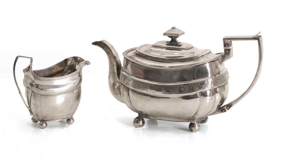 A George III silver teapot, Solomon Hougham, London, 1809,: A George III silver teapot, Solomon Hougham, London, 1809, with trailing vine decoration and ivory insulators to the handle, together with a similar milk jug, Ivory Declaration Submission Reference: