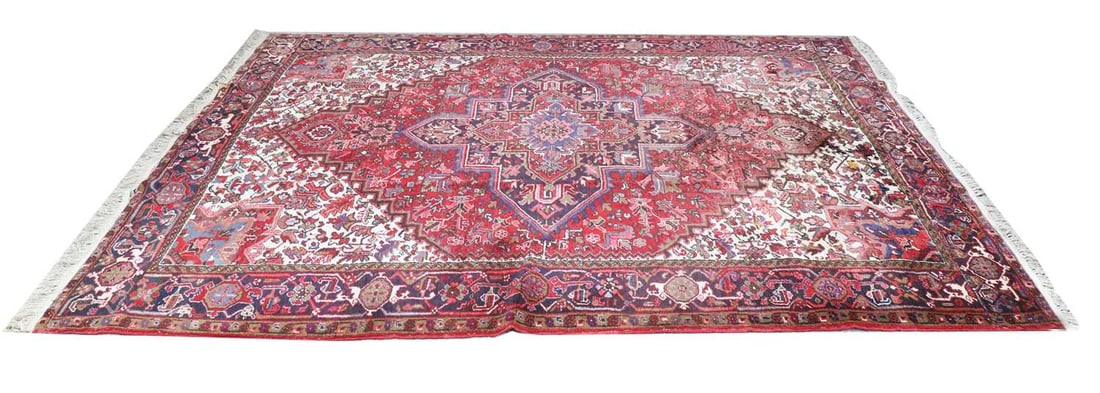 A Large Heriz Rug, 20th century: A Large Heriz Rug, 20th century with red ground, with blue border, and central eight pointed medallion, 349x263cm