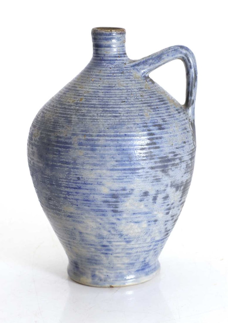 A Martin Brothers glazed stoneware ewer, dated 1909,: A Martin Brothers glazed stoneware ewer, dated 1909, the blue mottled glaze with a horizontal ribbed body, with a handle, with a graduated circular design to the top, with a short neck, incised marks