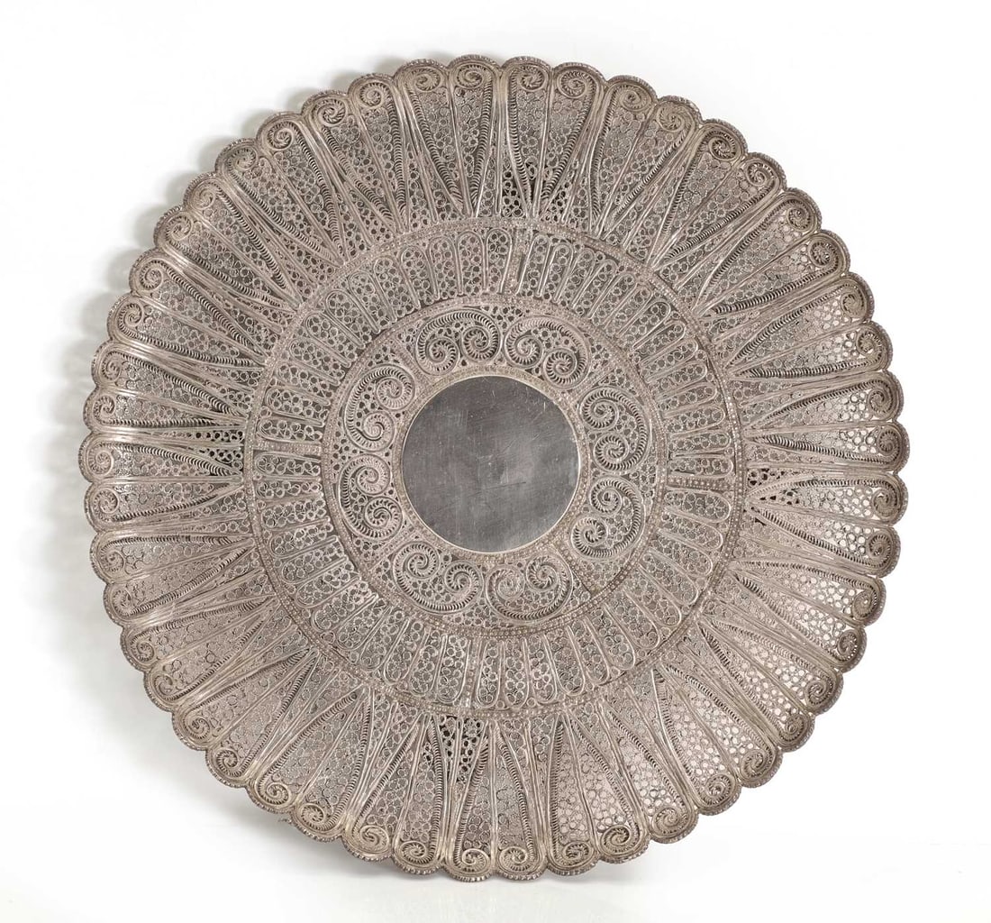 A silver filigree dish or comport, unmarked, tests silver,: A silver filigree dish or comport, unmarked, tests silver, possibly Portuguese, on four looped feet 27cm diameter, 21ozt Condition Report: Fair overall. Some scratches and wear.