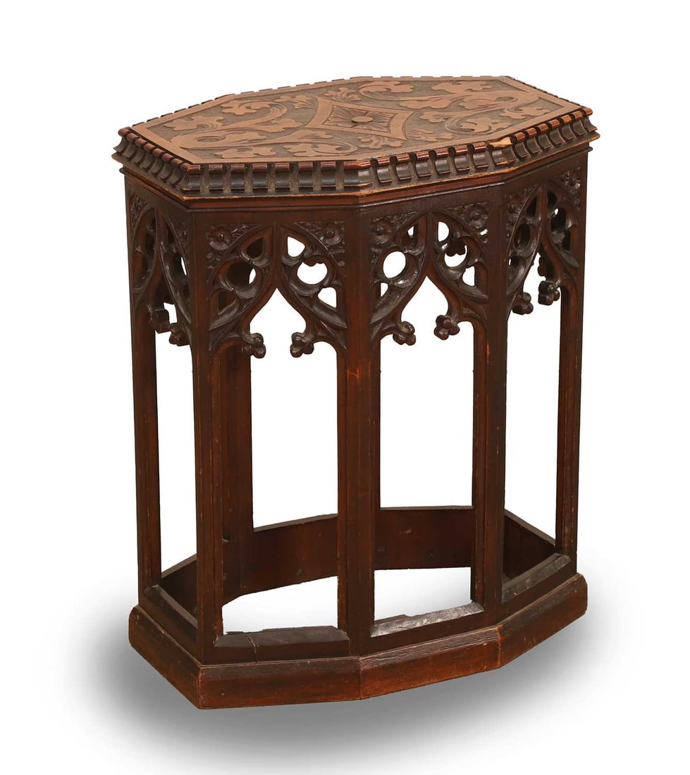 An octagonal walnut gothic stand, 19th century, French,: An octagonal walnut gothic stand, 19th century, French, with an architectural apron, and the top carved with foliate details, and with dentil rim 45cm wide, 31cm deep, 56cm high Provenance: The