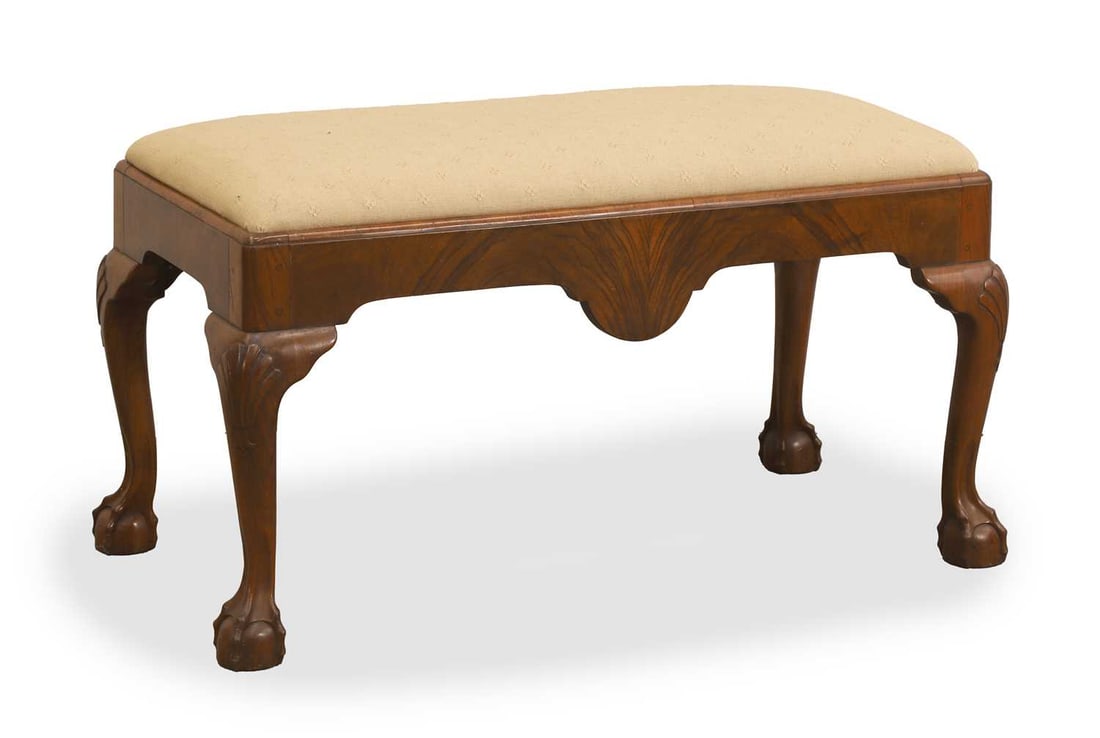 A Queen Anne style walnut stool, 20th century,: A Queen Anne style walnut stool, 20th century, with a cream drop in seat, a shaped apron, on cabriole legs and claw and ball feet 95cm wide, 48cm deep, 53cm high