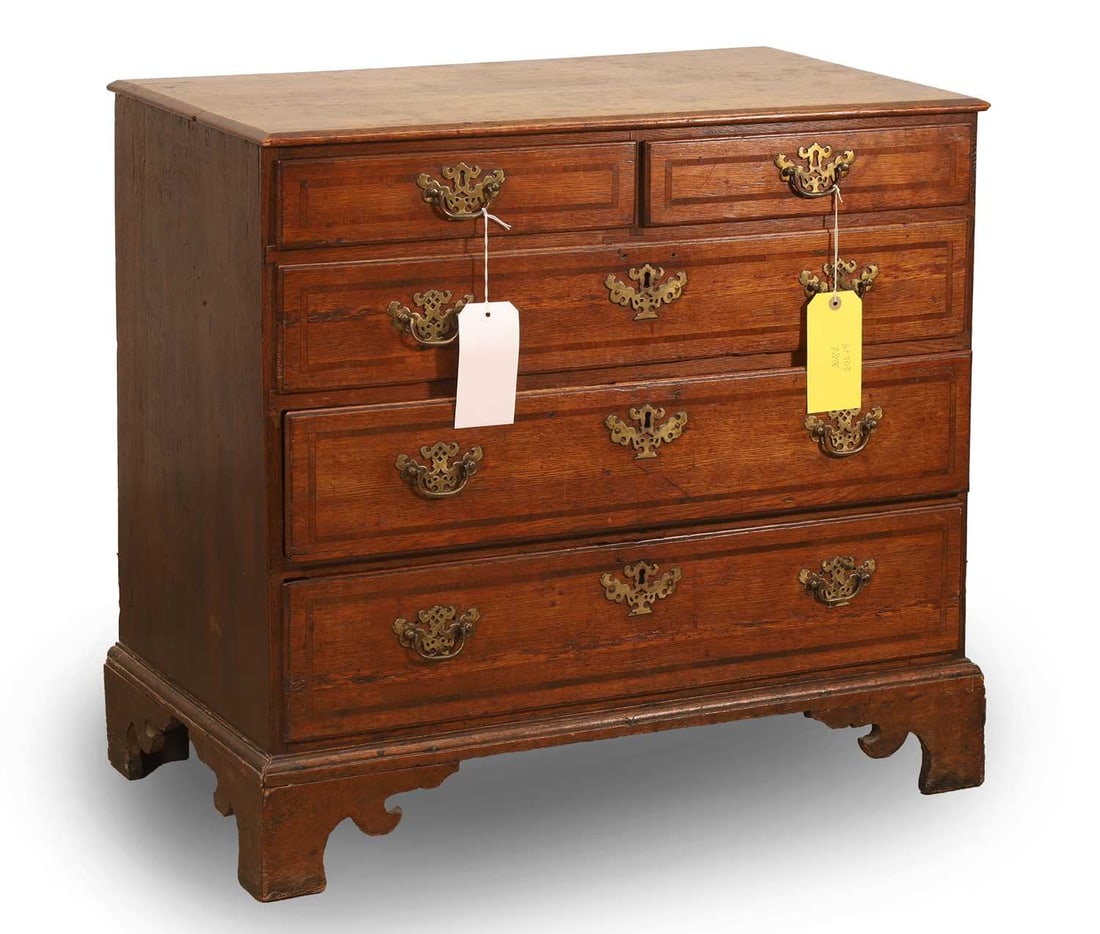 A George III oak and crossbanded chest of two short over three long drawers, late 18th century,: A George III oak and crossbanded chest of two short over three long drawers, late 18th century, with pierced brass handles and lock plates, on bracket feet 77cm wide, 47cm deep, 72cm high Provenance: