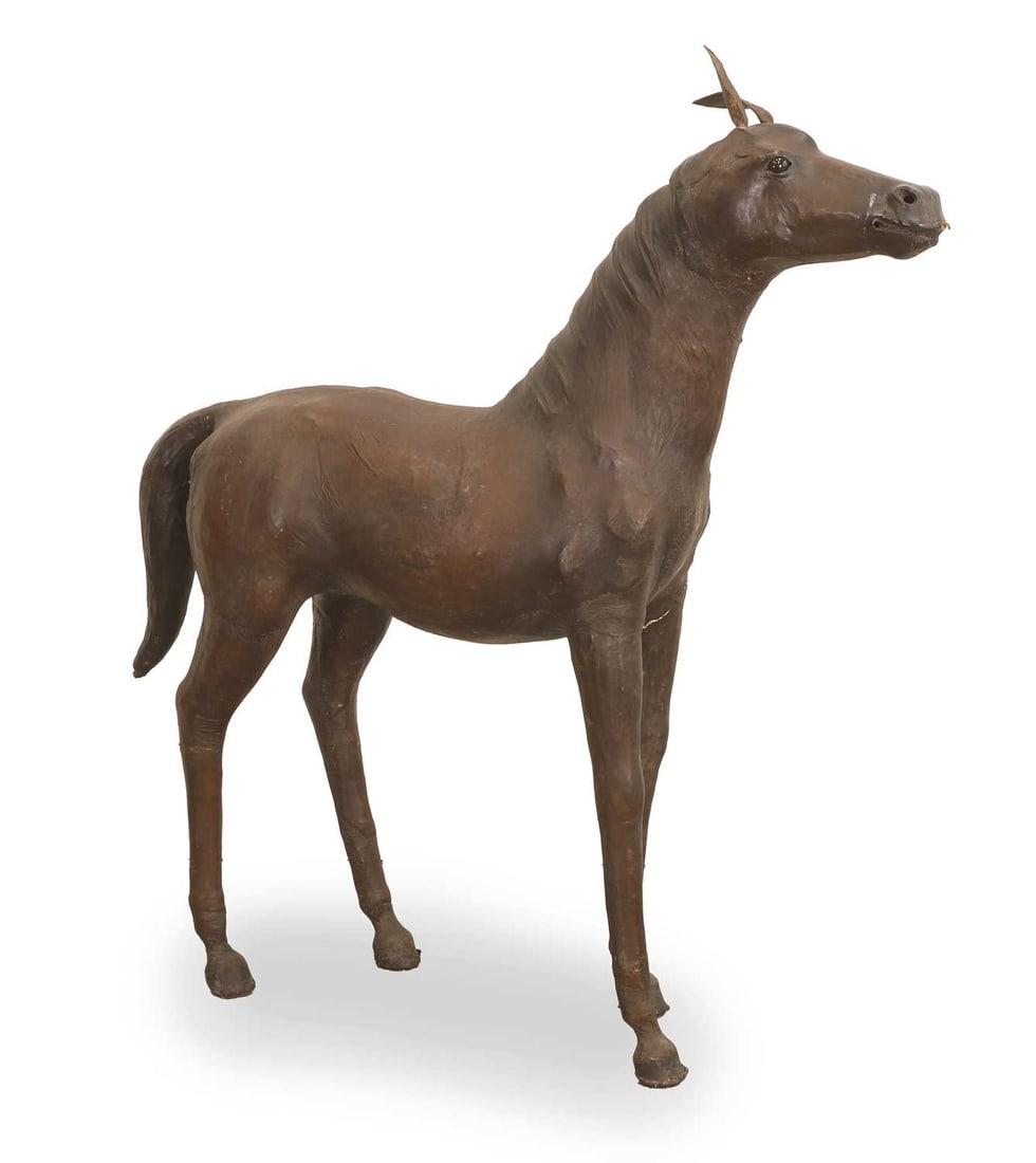 A Liberty-style leather horse, 20th century: A Liberty-style leather horse, 20th century standing with head raised, fitted with black glass eyes 100cm long, 112cm high