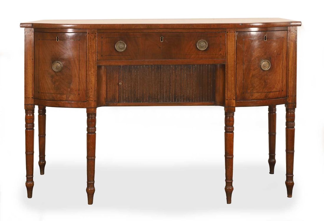 A George III mahogany bow-front sideboard, late 18th century,: A George III mahogany bow-front sideboard, late 18th century, having three drawers with a tambour-fronted cupboard beneath 137cm wide, 56cm deep, 90cm high Condition Report: old knocks dents and