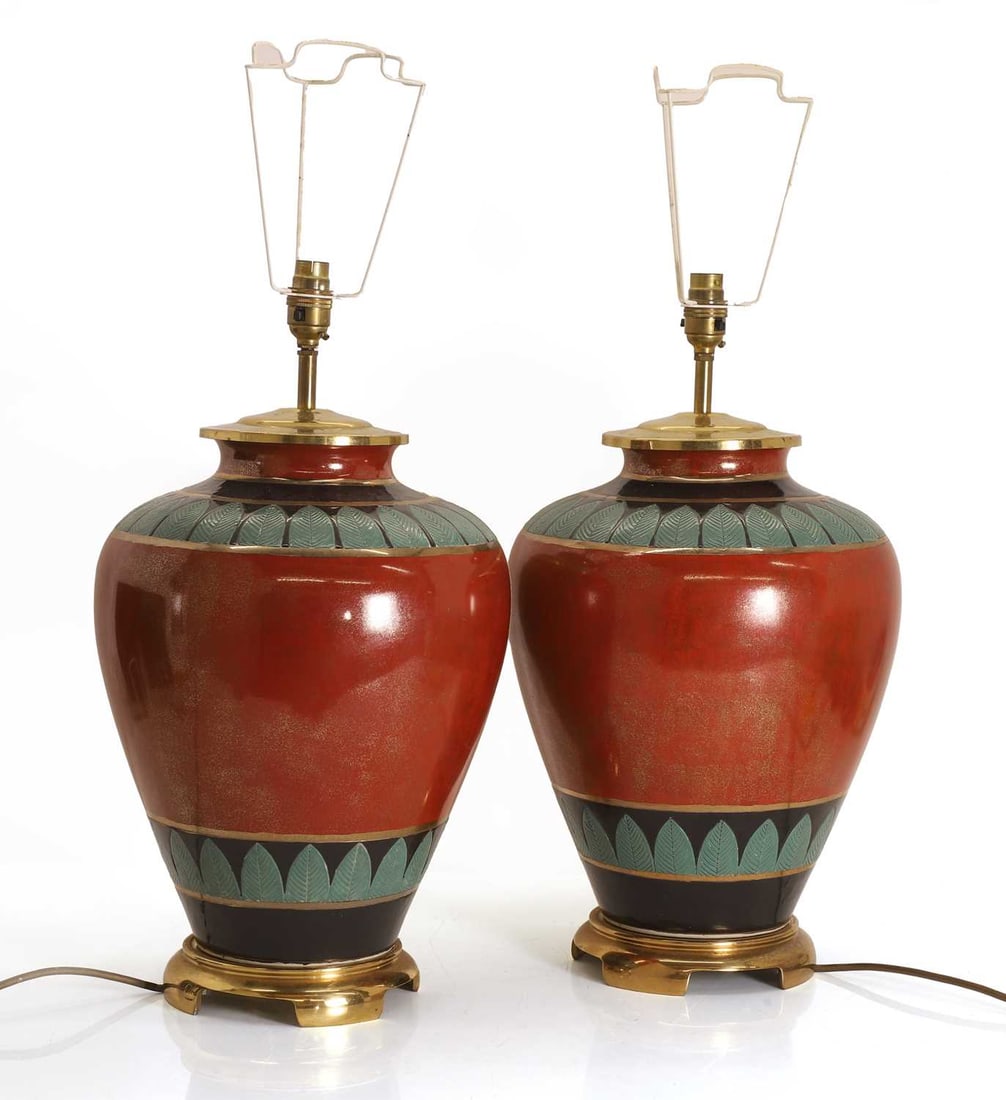 A pair of large Egyptian revival pottery table lamps, 20th century,: A pair of large Egyptian revival pottery table lamps, 20th century, with banding decorated with palm leaves on brass base, together with cream shades 29cm wide, 48cm high 2 Provenance: The contents