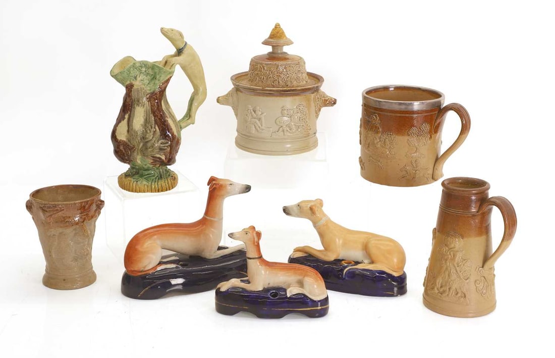 Four salt glazed stoneware items, late 19th century,: Four salt glazed stoneware items, late 19th century, a tankard, with a silver rim, Sheffield, 1883, a pot and cover, a tapering ewer, a mask beaker, three Staffordshire greyhounds, and a majolica