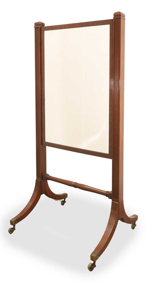 A Regency mahogany cheval mirror, circa early 19th century,: A Regency mahogany cheval mirror, circa early 19th century, with a rectangular rise and fall mirror plate, with reeded supports, with arabesque finials, a ringed turned stretcher raised on brass caps
