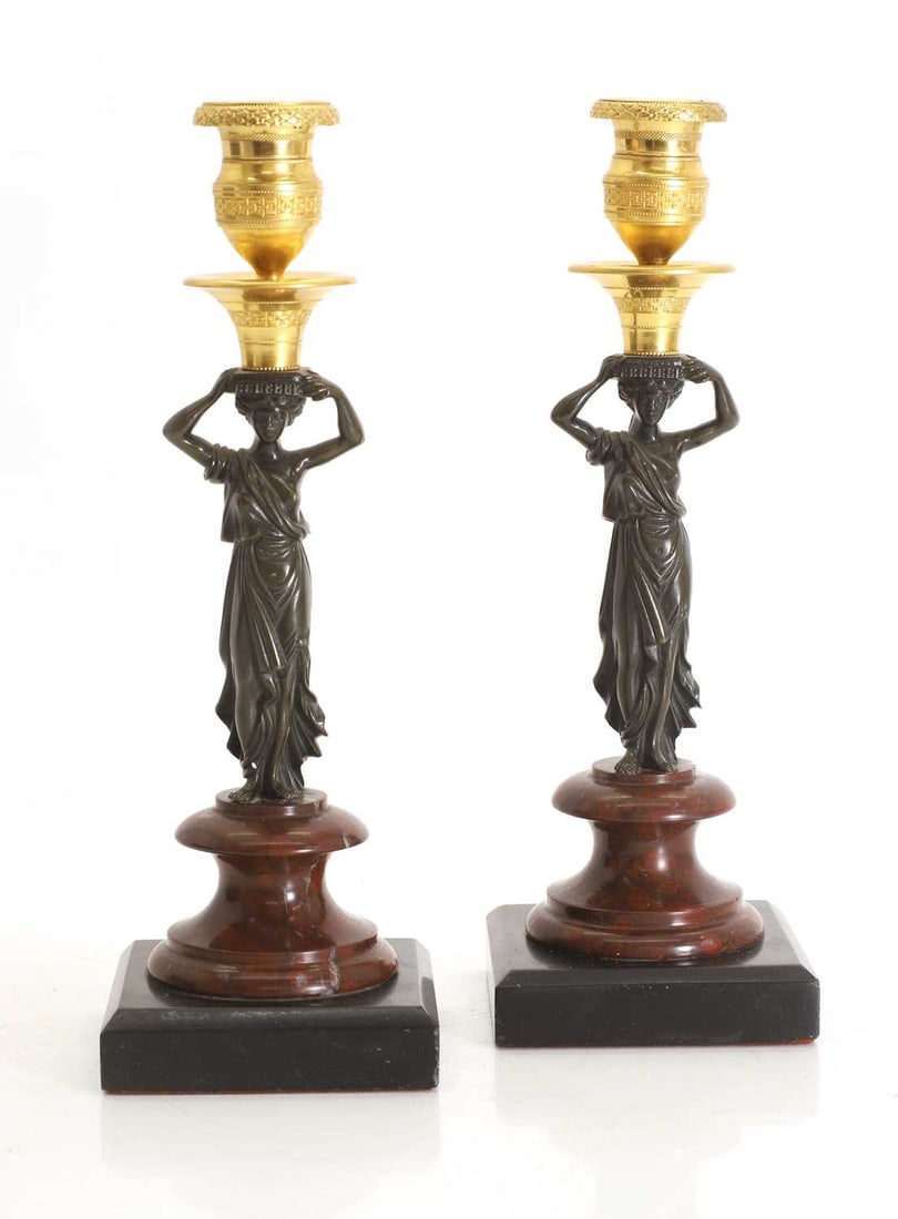 A pair of bronze and ormolu candlesticks, 20th century: A pair of bronze and ormolu candlesticks, 20th century each in the form of a female figure holding the sconce upon her head, raised on a rouge marble and slate base 9cm wide, 9cm deep, 27cm high