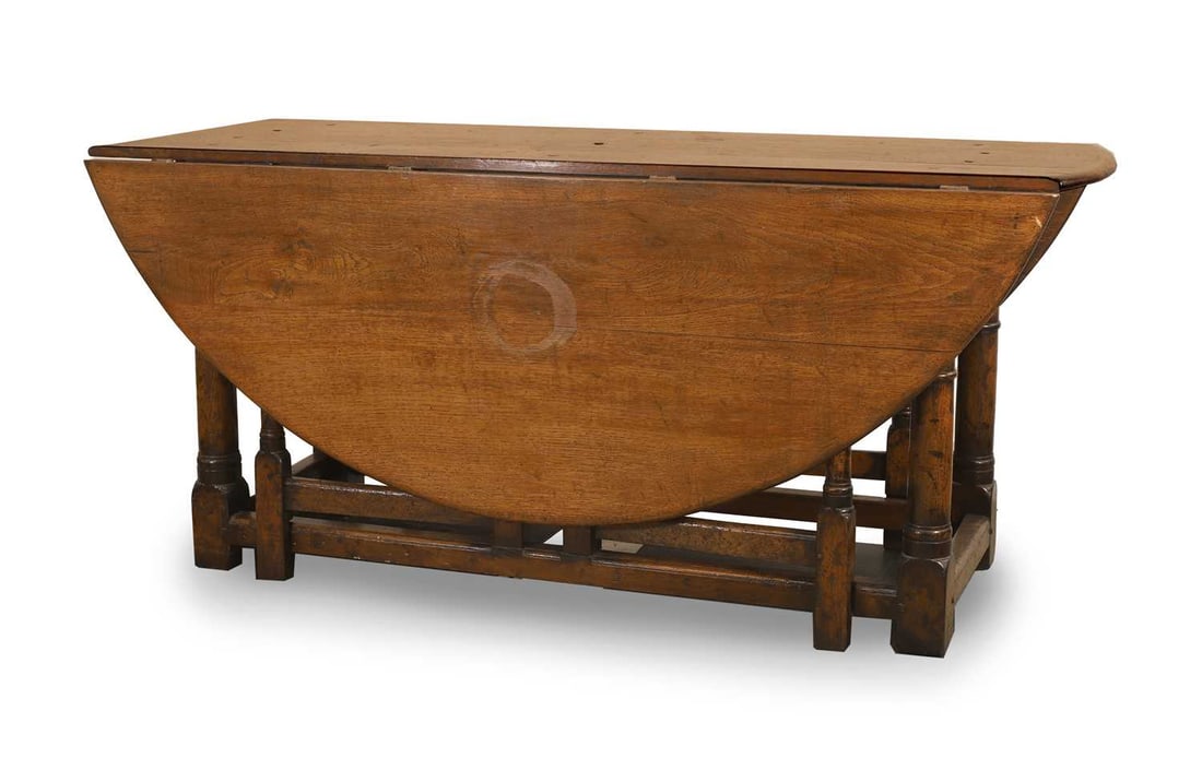 A large oak double gate leg dining table and eight Windsor chairs 20th century,: A large oak double gate leg dining table and eight Windsor chairs 20th century, the table with an oval top, raised on ring turned base, united by stretchers (six arms, two standard) 167cm wide, 180cm
