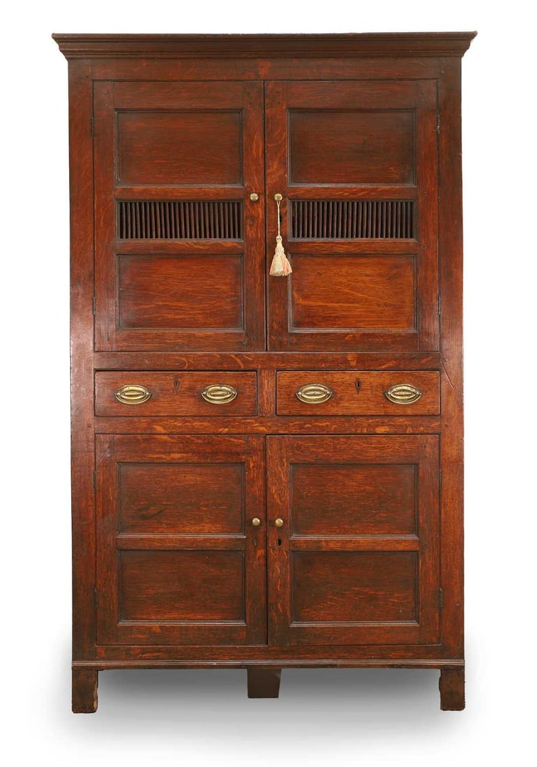 An oak bread and cheese cupboard or 'Cwpwrdd Bara Caws', late 18th century, Welsh,: An oak bread and cheese cupboard or 'Cwpwrdd Bara Caws', late 18th century, Welsh, the panelled doors fitted with a spindle grille 114cm wide, 50cm deep, 188cm high Provenance: The contents of