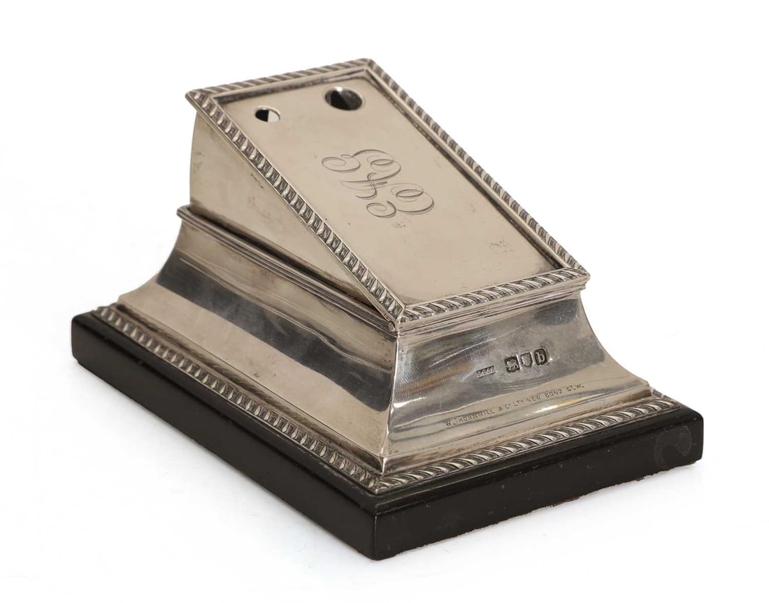 A silver cigar cutter stand, by John Grinsell & Sons, London 1897,: A silver cigar cutter stand, by John Grinsell & Sons, London 1897, on an ebonised plinth, monogrammed and retailed by W Thornhill & Co Ltd New Bond Street., with a sprung cutter 13.5cm wide,