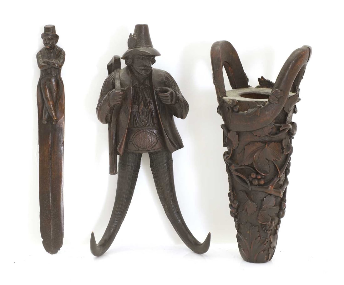 A Black Forest double horn and wood coat hook and a pot and letter opener, mid 19th century,: A Black Forest double horn and wood coat hook and a pot and letter opener, mid 19th century, .modelled as a hunter, the pot of tapering form, carved with fruiting vines, the letter opener the handle