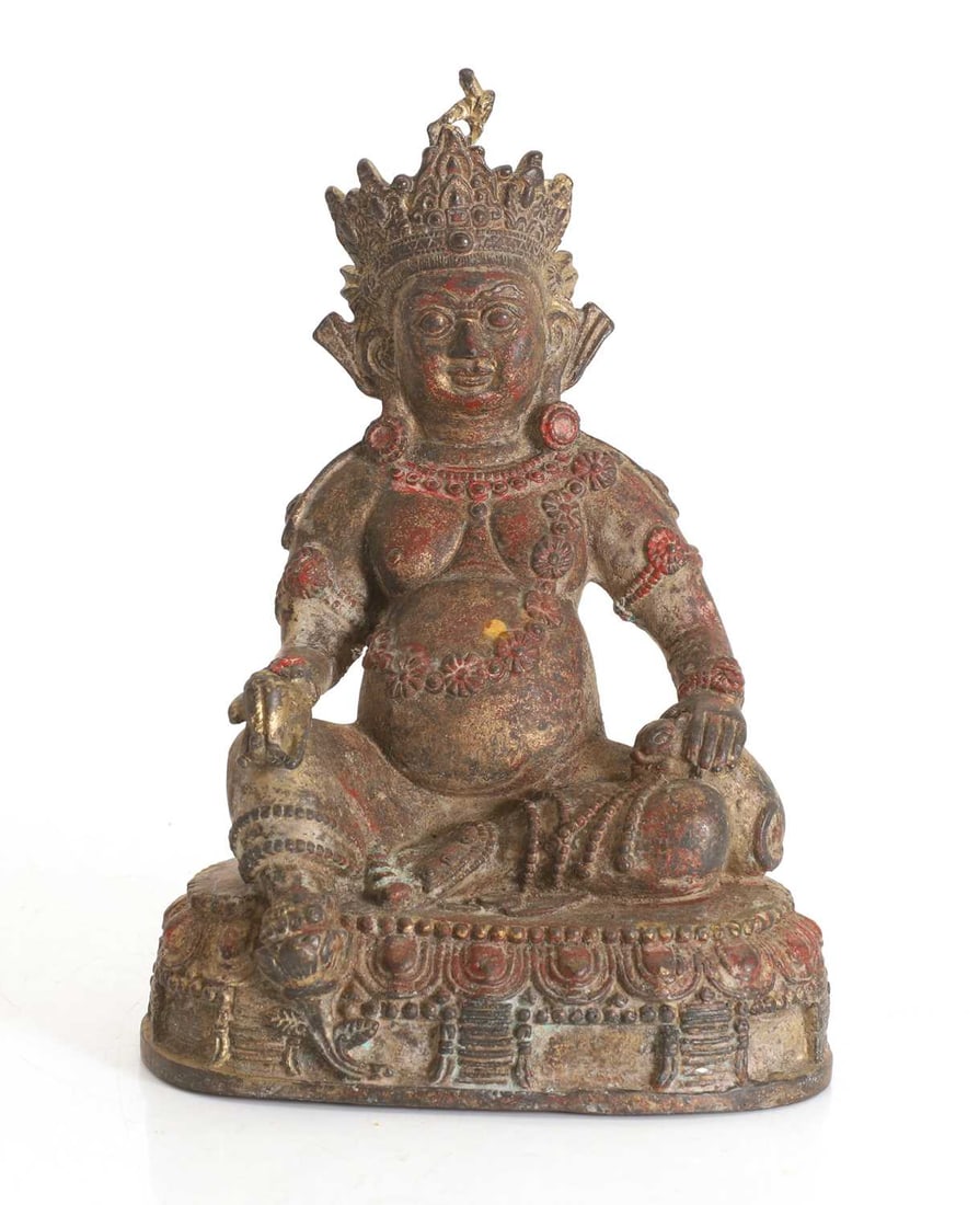A Tibetan polychrome painted cast-metal figure of Jambhala,: A Tibetan polychrome painted cast-metal figure of Jambhala, cast seated in lalitasana on a lotus pedestal holding a citron in the right hand, a mongoose in the left, adorned with jewellery 24cm high