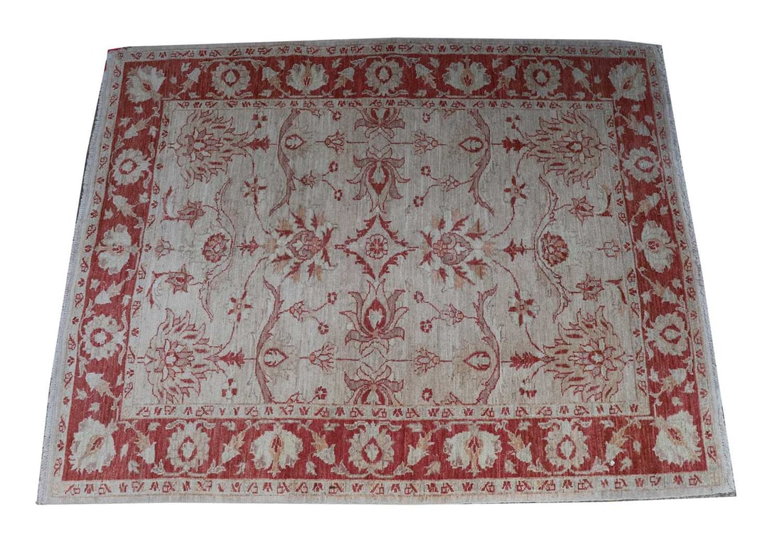 A Ziegler rug,: A Ziegler rug, with ivory ground with foliate red border 207 x 152cm Condition Report: Tassels cut down and colour faded.