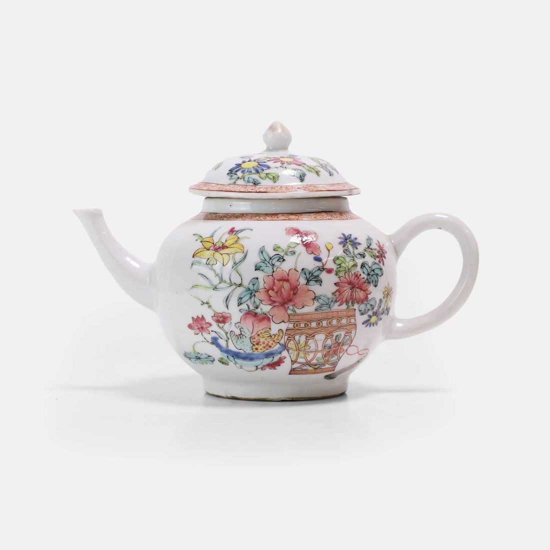 A Chinese famille rose teapot, 18th century,: A Chinese famille rose teapot, 18th century, painted with a basket issuing peony and chrysanthemum, beside a bowl of lotus, finger citrons and peaches, the cover similarly decorated 20cm long 2 Footno