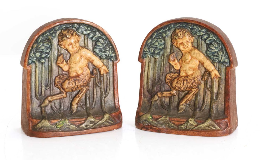 A pair of Compton Art Potters' Guild Compton Pottery bookends, 20th century,: A pair of Compton Art Potters' Guild Compton Pottery bookends, 20th century, each moulded with a faun against a wooded panel 2 Footnote: The Compton Art Potters' Guild was founded by Mary Watts (n