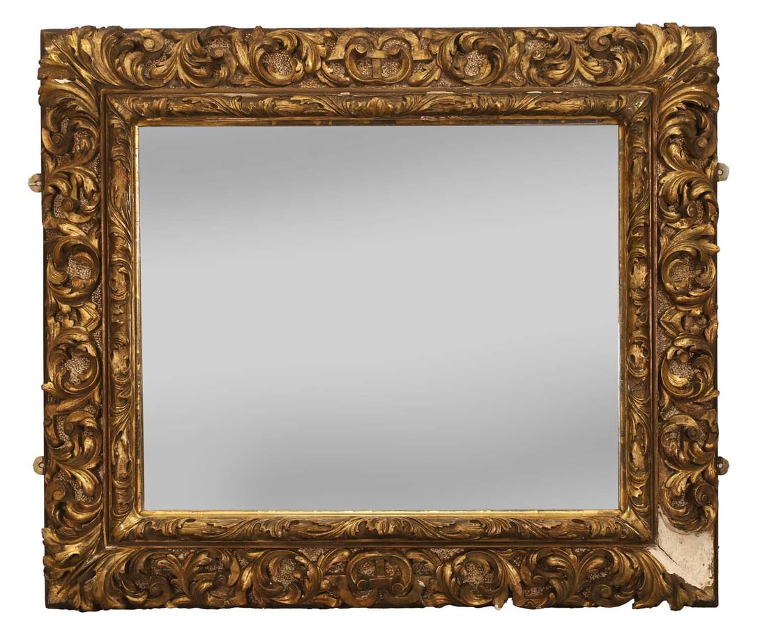 An ornate carved and giltwood mirror, 19th century,: An ornate carved and giltwood mirror, 19th century, with a rectangular plate and acanthus ornaments 93cm wide, 79cm high Provenance: The contents of Thornton House, Clare. Condition Report: Loss