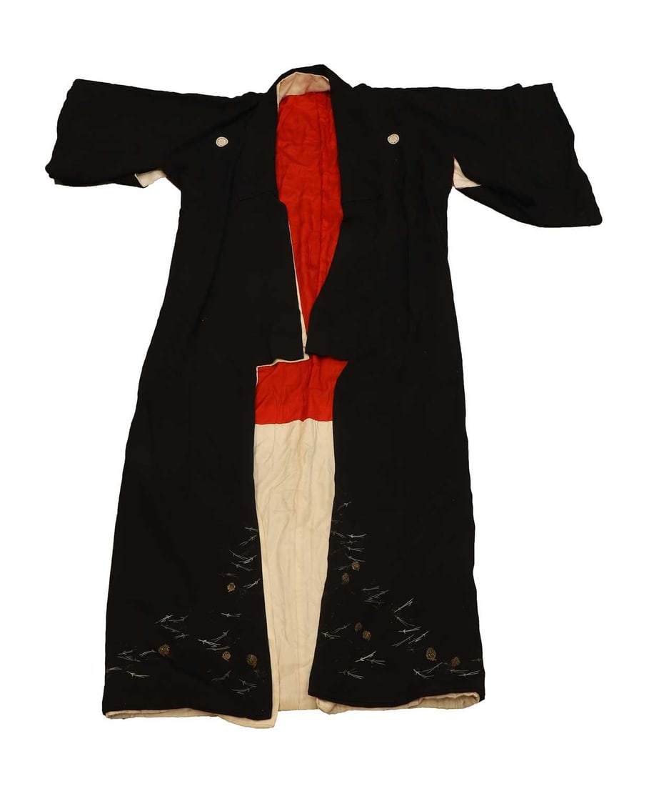 A Japanese kimono, 20th century,: A Japanese kimono, 20th century, the black outer layer embroidered with the Katabami (Wood Sorrel) crest to the chest, arms and back of the neck, the lower section decorated with stylised pine cones