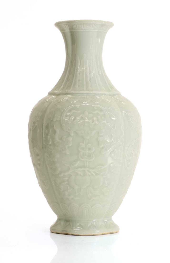 A Chinese celadon glazed vase,: A Chinese celadon glazed vase, the quatrefoil cross-sectioned body with moulded decoration of stylised bats, clouds, and pomegranates, the waisted neck with key fret and lappet borders, four-character