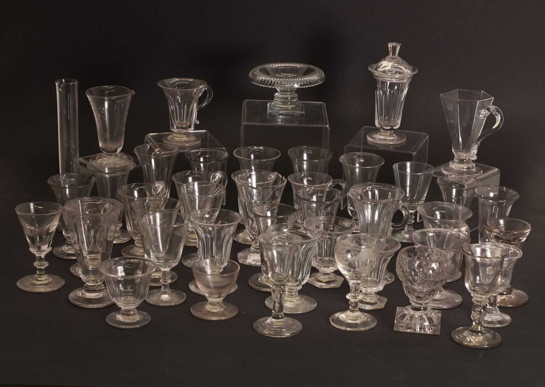 A large quantity of table glass, 18th century and later,: A large quantity of table glass, 18th century and later, comprising jelly, bonnet, and custard glasses, to include two panel-moulded examples, a roll rim, and two measuring glass tallest 20.5cm high 4