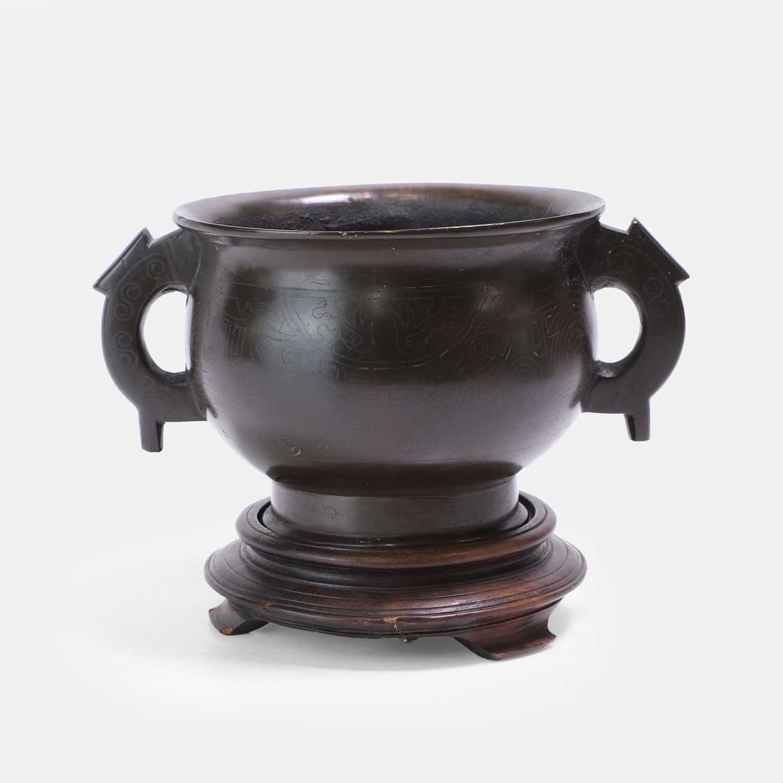 A Chinese bronze incense burner, Qing dynasty (1644-1911),: A Chinese bronze incense burner, Qing dynasty (1644-1911), the globular body, rising from a slightly flared foot, flanked by two 'C'-shaped handles, inlaid with taotie masks in silver wire, with a