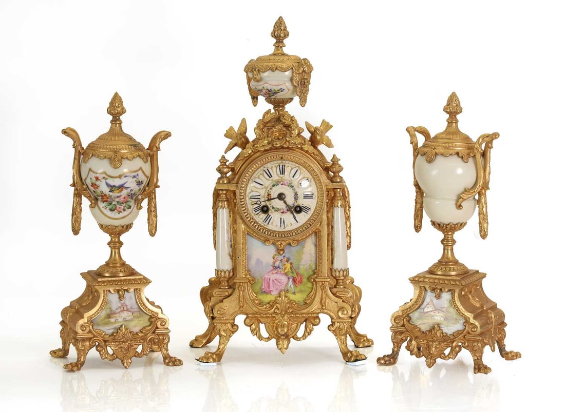 A French gilt metal clock garniture inset with porcelain panels, late 19th century,: A French gilt metal clock garniture inset with porcelain panels, late 19th century, the porcelain dial with Roman numerals in white panels and central painted scene of a courting couple, in a decorati