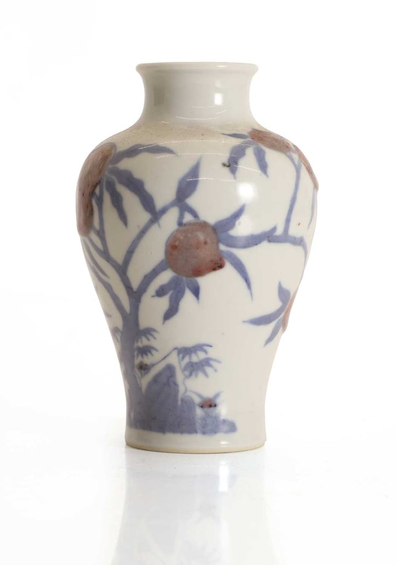 A Chinese porcelain baluster vase,: A Chinese porcelain baluster vase, painted in underglaze blue with stylised foliage issuing pomegranates, with a six-character Kangxi mark to base 13cm high