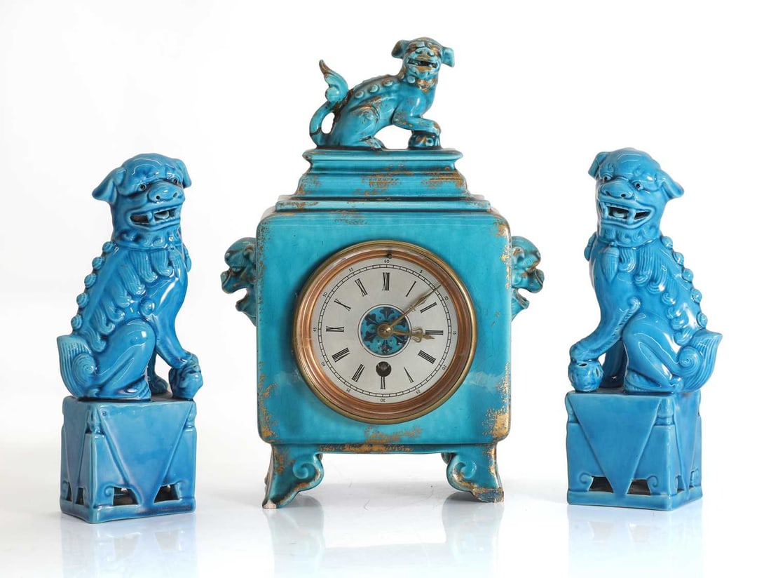 A Chinese blue glazed mantel clock,: A Chinese blue glazed mantel clock, the face with Roman chapter ring, together with associated dogs of fo in similar blue glaze on rectangular bases Clock, 18cm wide, 28cm high 3 Condition Report: The