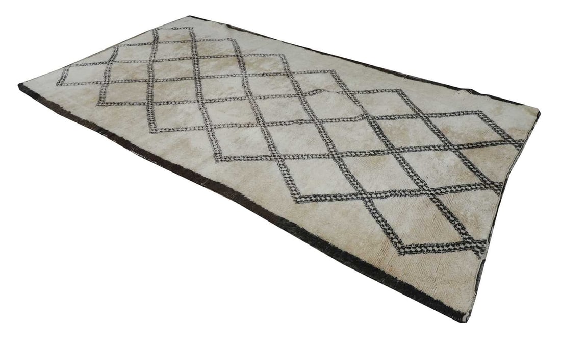 A Koranni style rug, circa 1960,: A Koranni style rug, circa 1960, the black ground, with white field, and geometric central pattern 202x361cm