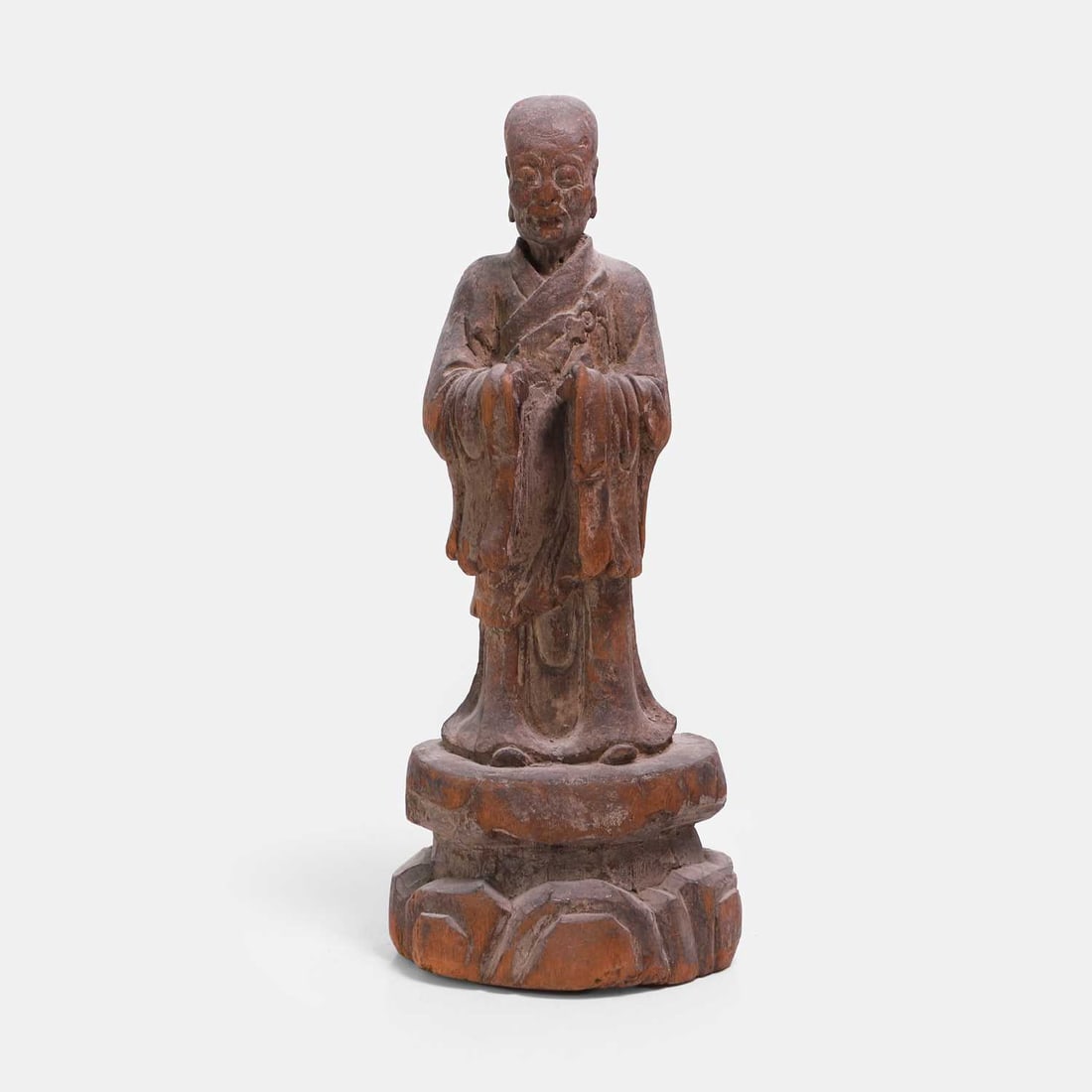 A Japanese wood figure, Taisho period (1912-1926),: A Japanese wood figure, Taisho period (1912-1926), of a monk standing on a rock, wearing a kesa tied with a circular clasp to his chest 39cm high