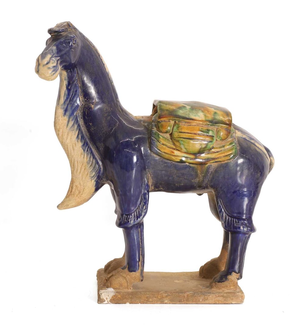 A Tang style pottery camel, 20th century,: A Tang style pottery camel, 20th century, modelled with saddle on the back, with sancai glaze on a rectangular base 26cm wide, 30cm high Provenance: The contents of Thornton House, Clare. Condition