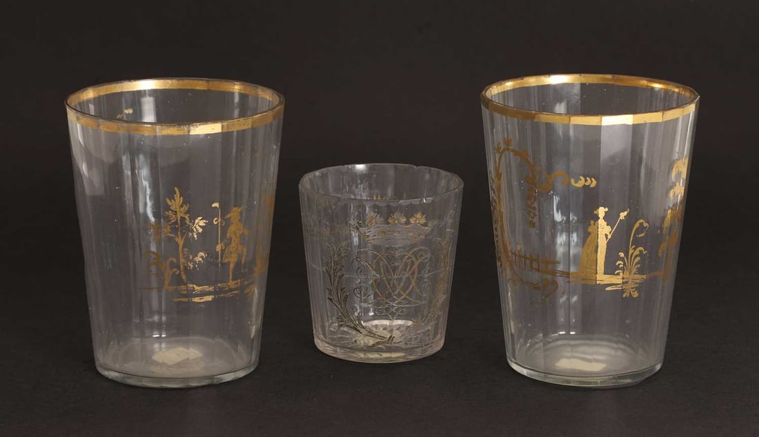 A pair of glass beakers, circa 1800, probably Bohemian, decorated in the style of James Giles,: A pair of glass beakers, circa 1800, probably Bohemian, decorated in the style of James Giles, of faceted form, each decorated with a lady and a gallant, and a similar beaker, engraved with a cipher