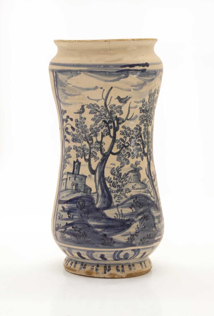 A blue and white tin glazed albarello drug jar, 18th/19th century,: A blue and white tin glazed albarello drug jar, 18th/19th century, painted with a landscape scene 11cm wide, 22cm high Condition Report: Some chipping and fritting to the exterior. Some cracking. The 