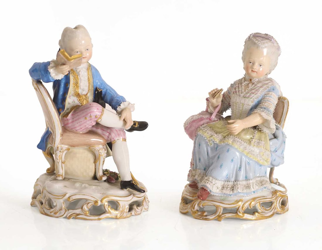 A pair of Meissen porcelain figures, 19th century,: A pair of Meissen porcelain figures, 19th century, modelled as a man seated reading a book, and a woman seated holding a tatting shuttle, the bases with blue underglaze marks, and impressed number '12