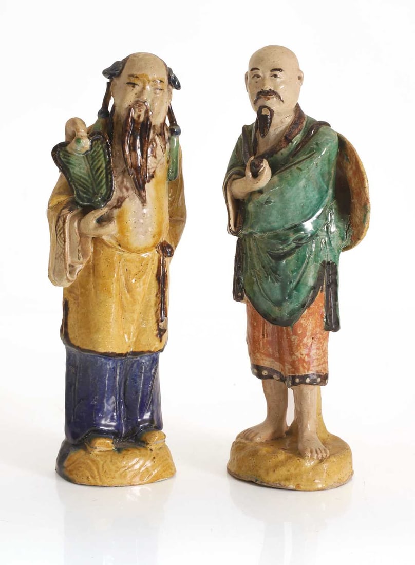 Two Chinese pottery glazed figures, 20th century,: Two Chinese pottery glazed figures, 20th century, each modelled standing on a naturallistic base, one example with a pipe on his shoulder, the other holding a fan 27.5cm high 2 Condition Report: Some