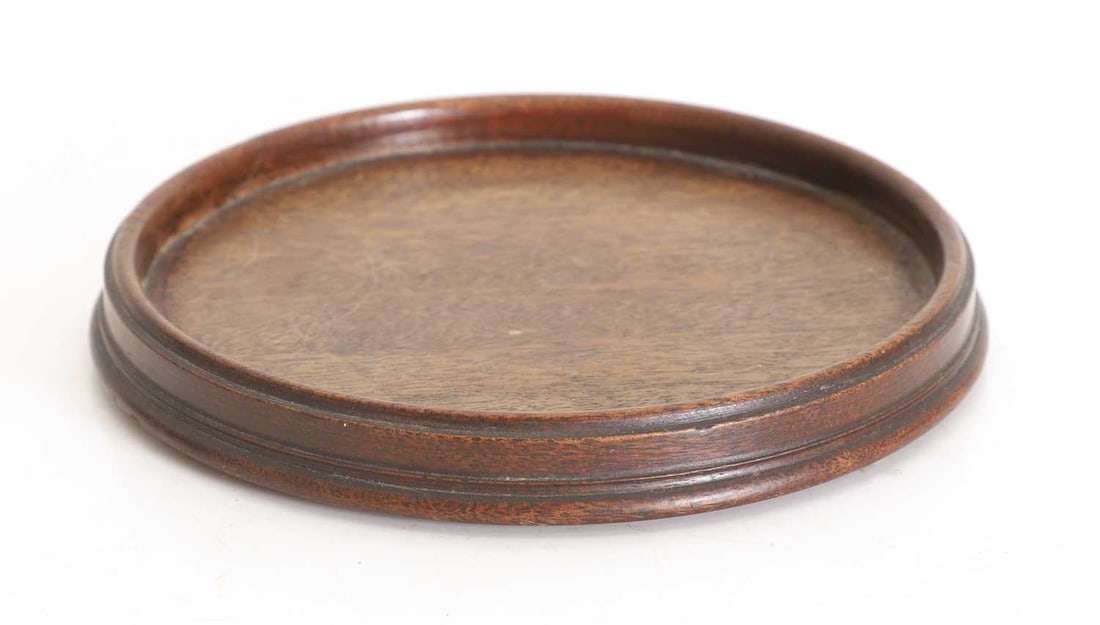 A turned mahogany wine coaster, early 19th century,: A turned mahogany wine coaster, early 19th century, of turned circular form 15cm diameter Condition Report: Cleaned, surface degraded, light knocks and dents.