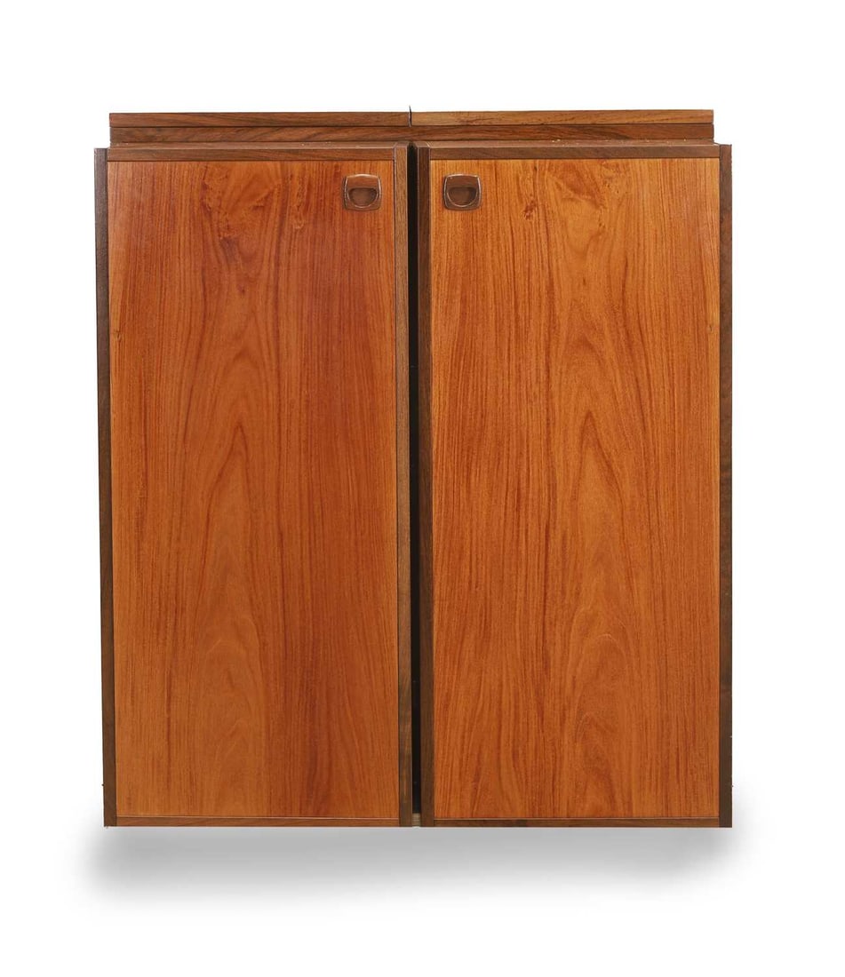A teak cocktail bar, circa 1970s,: A teak cocktail bar, circa 1970s, with a pair of cupboards, enclosing shelves, and further shelves to the interior, with a double hinged and vinyl folding surface to the top, on castors 80cm wide, 45c