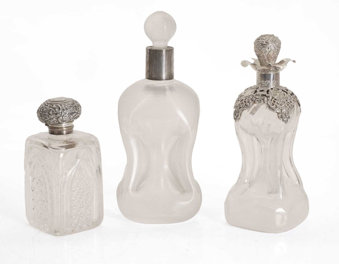 A silver mounted decanter and a scent bottle, various marks,: A silver mounted decanter and a scent bottle, various marks, with a ribbed and pinched body, the scent bottle with a stopper and a hinged cover, together with another scent bottle, with a silver-mount