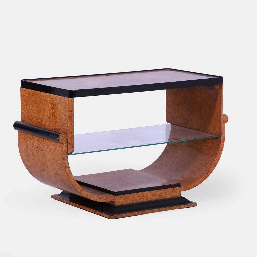 Hille, an Art Deco burr maple and ebonised side table,: Hille, an Art Deco burr maple and ebonised side table, 1930s, with a rectangular top with a raised edge, and a glass undertier, on a 'U'-shaped stand and a shaped plinth (98cm wide, 46cm deep, 62cm hi