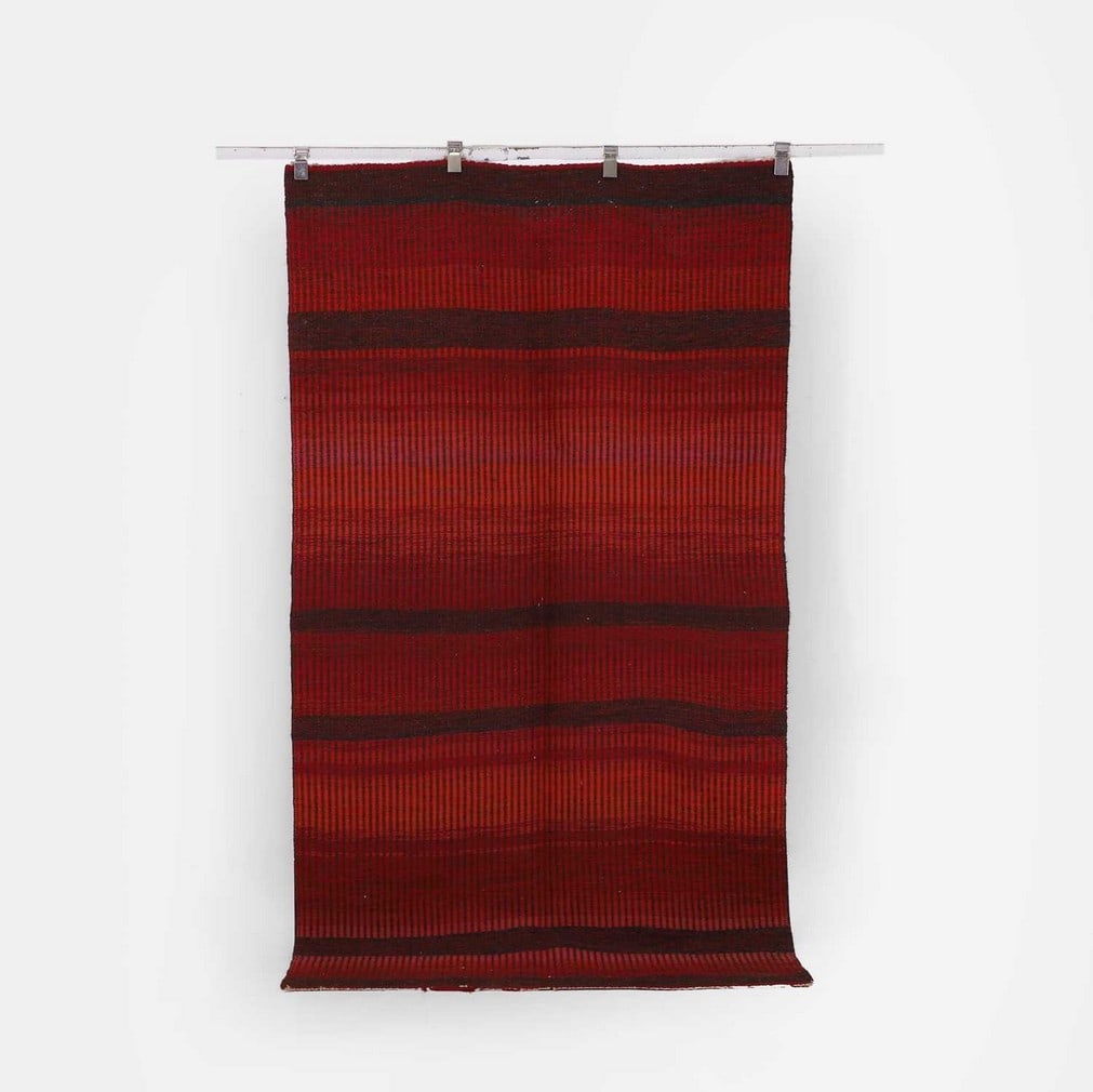 ▲ Peter Collingwood (British, 1922-2008), a rug,: ▲ Peter Collingwood (British, 1922-2008), a rug, mid-20th century, wool and horsehair, in tones of red and burgundy (229 x 123cm) Condition Report: End threads worn, some fraying to one end.