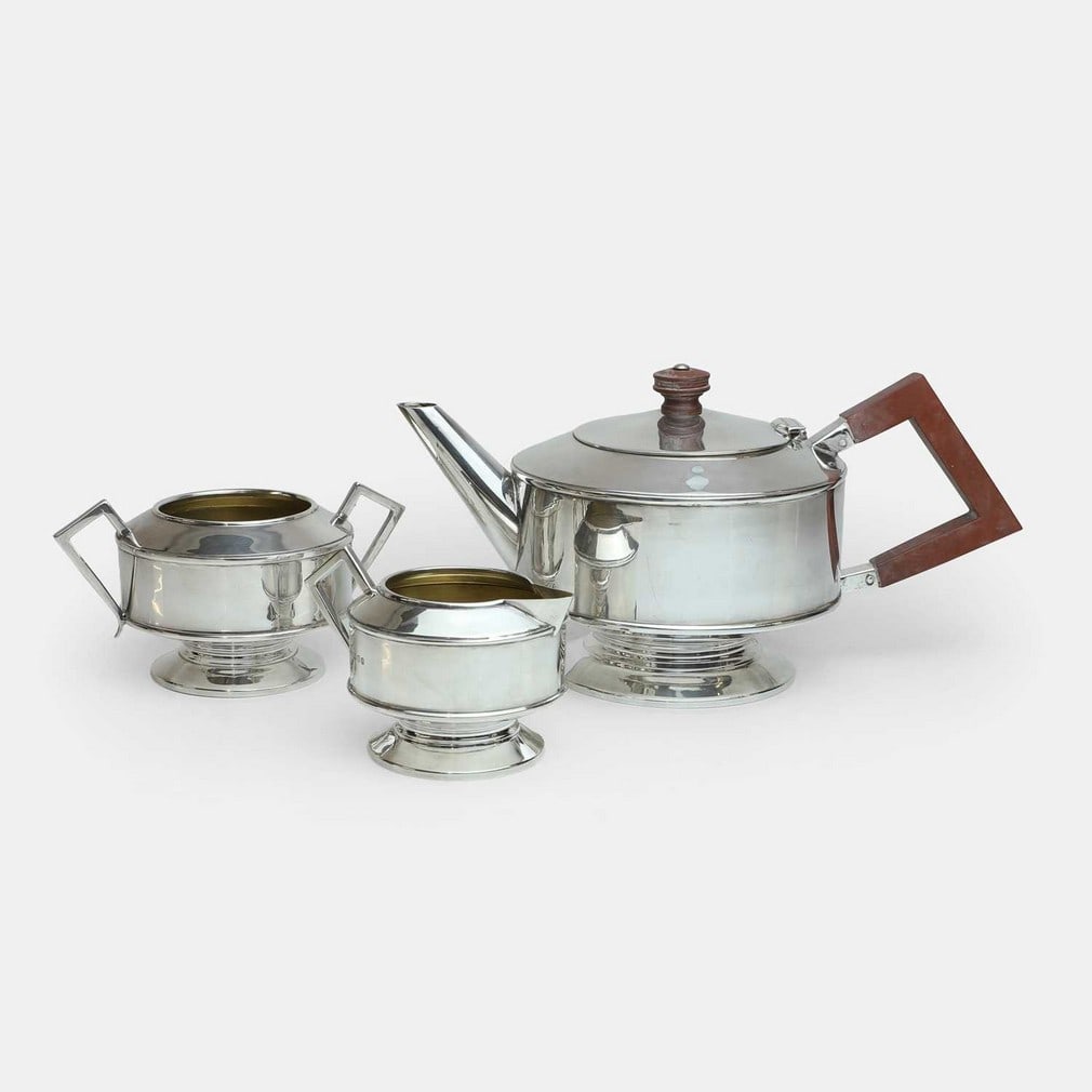 English, an Elizabeth II three-piece silver tea set,: English, an Elizabeth II three-piece silver tea set, London, 1968, comprising a teapot with wooden handles, a milk jug and sugar bowl (teapot 30cm wide, 16cm deep, 14cm high) (3) Condition Report: Ove