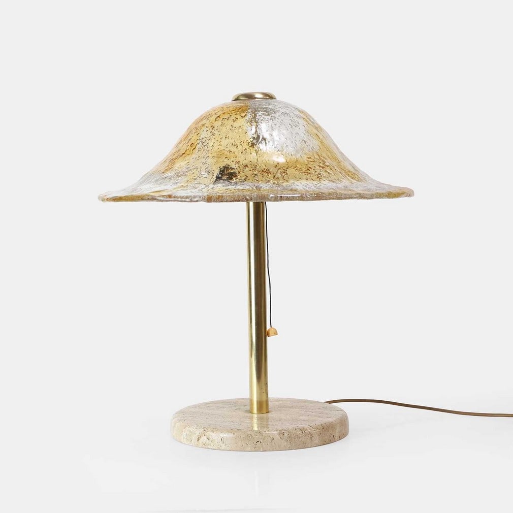 Temde, a 'mushroom' table lamp,: Temde, a 'mushroom' table lamp, circa 1970s, Swiss, the amber-tone glass mushroom-form shade over a cylinder brass stem, raised on a circular travertine marble base, stamped 'Temde' (46cm diameter,